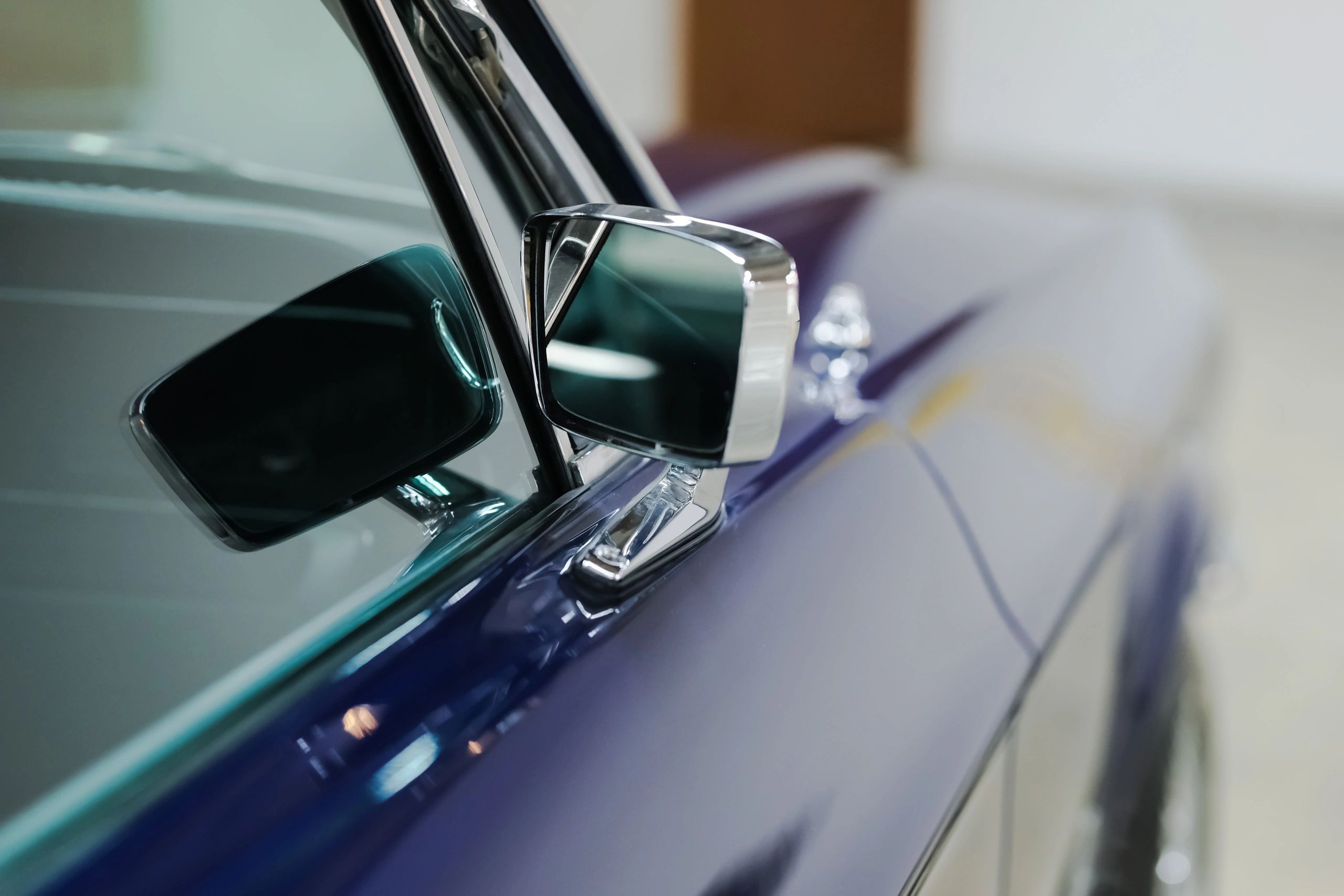 Close-up detail of a restored classic car side mirror and window